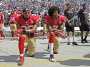 Colin Kaepernick (7) and Eric Reid (35) kneel during the national anthem before an NFL game in 2016. Kaepernick and Reid have reached settlements on their collusion lawsuits against the NFL, the league said Friday, Feb. 19, 2019.