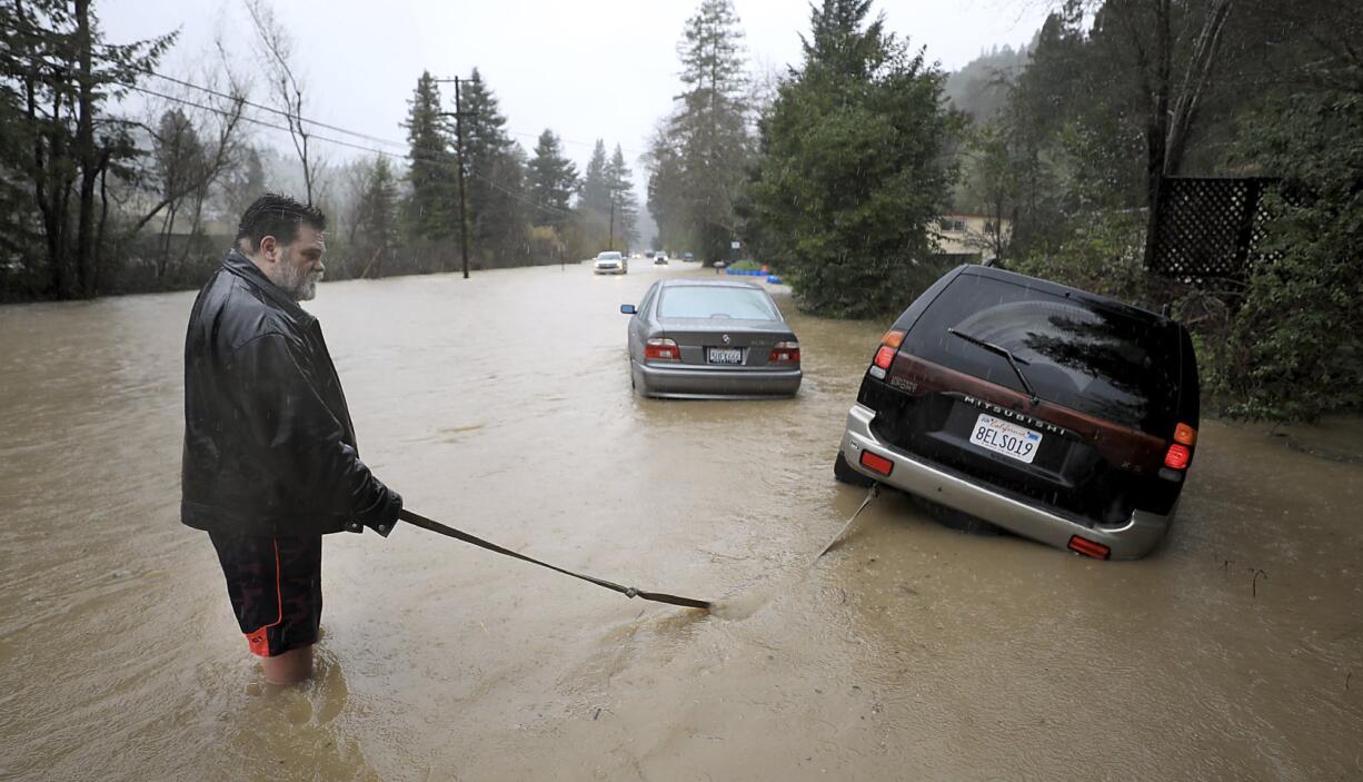 Tim Russell of Guerneville attempts to pull a motorist from Armstrong Woods Road after it became inundated in Guerneville, Calif., Tuesday, Feb. 26, 2019, but Russell became stuck himself. The town of Guerneville and some two dozen other communities are at risk of flooding from the Russian River north of San Francisco, which hit flood stage Tuesday evening and was expected to peak Wednesday morning at more than 46 feet - the highest point in nearly a quarter-century.