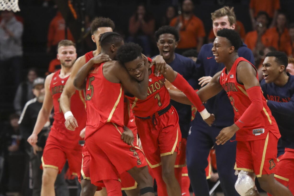 Arizona’s Brandon Randolph, left, and Brandon Williams, right, celebrate with Devonaire Doutrive, center, after Doutrive scored in the final second of the game, securing the win over Oregon State during an NCAA college basketball game in Corvallis, Ore., Thursday, Feb. 28, 2019. Arizona won 74-72.