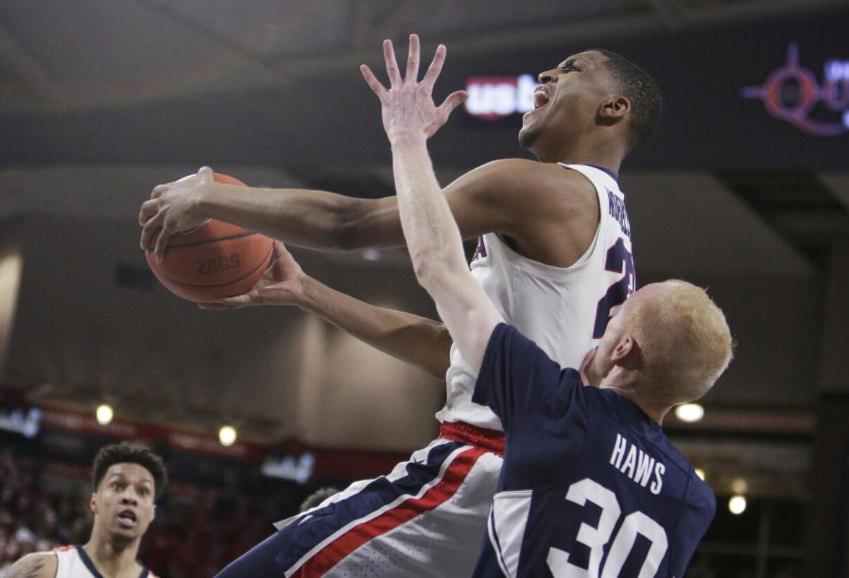 Gonzaga guard Zach Norvell Jr., top, shoots over BYU guard TJ Haws (30) during the first half of an NCAA college basketball game in Spokane, Wash., Saturday, Feb. 23, 2019.