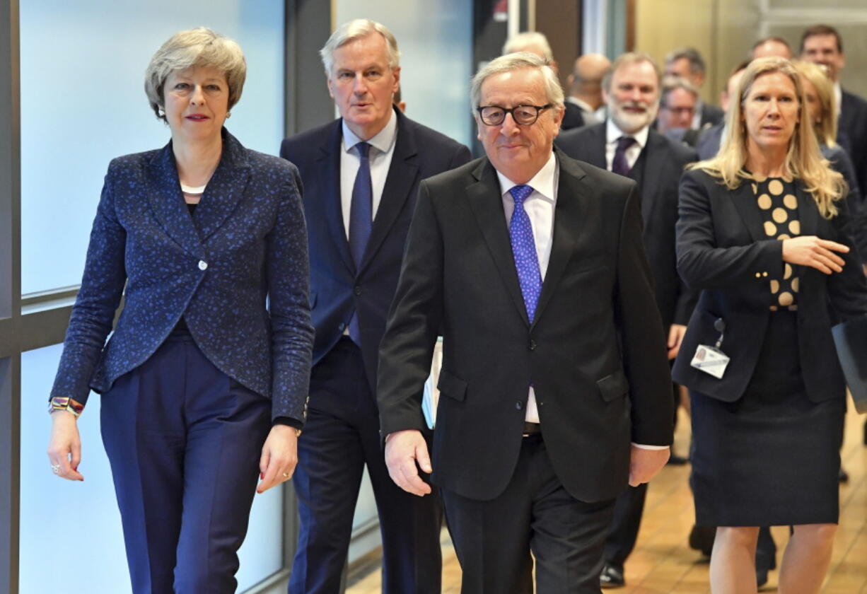 European Commission President Jean-Claude Juncker, British Prime Minister Theresa May and European Union chief Brexit negotiator Michel Barnier, center, walk to their meeting at the European Commission headquarters in Brussels, Thursday, Feb. 7, 2019.