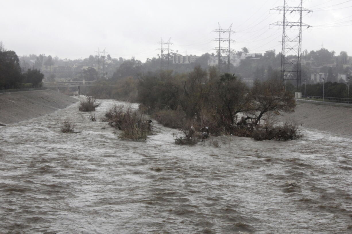 Runoff surges down the Los Angeles River near the Los Feliz district of Los Angeles, Calif., on Sunday, Feb. 3, 2019, during a weekend of stormy weather. The river, which normally flows at a trickle, filled bank to bank with fast-moving water. The National Weather Service said showers would diminish through the day.