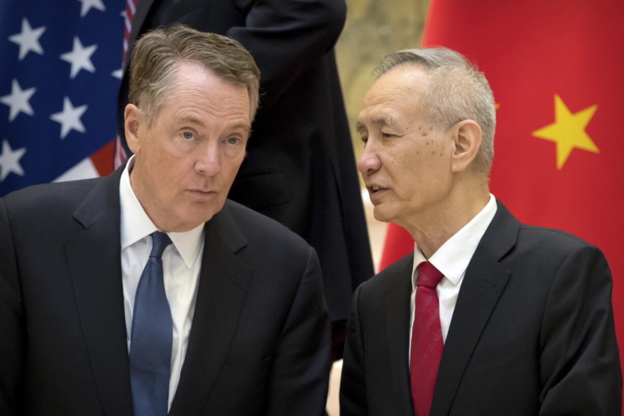 FILE - In this Feb. 15, 2019, file photo, Chinese Vice Premier Liu He, right, talks with U.S. Trade Representative Robert Lighthizer, while they line up for a group photo at the Diaoyutai State Guesthouse in Beijing.