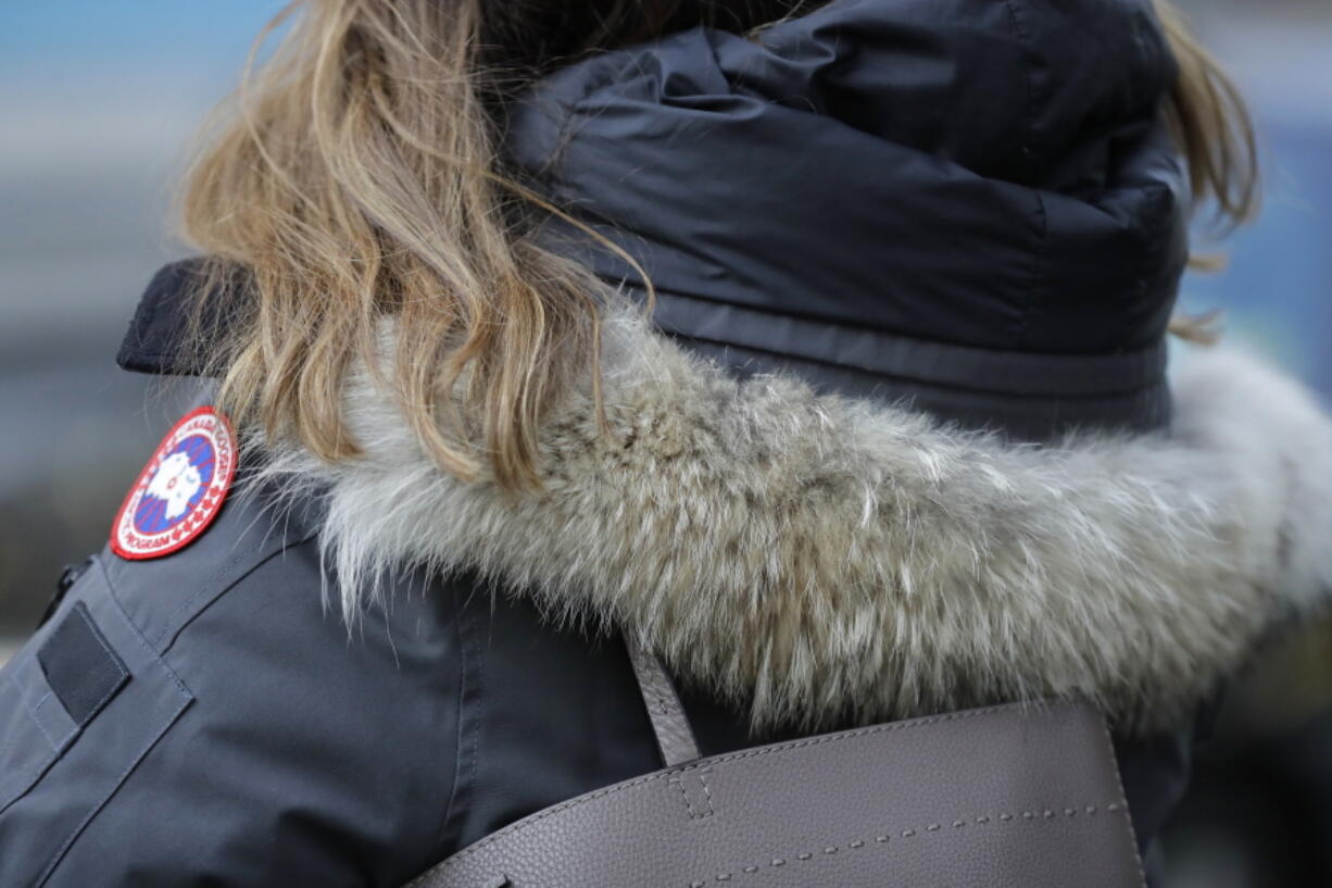 In this Feb. 14, 2019 photo, a woman in New York wears a Canada Goose coat with a hood fur trimmed with coyote fur. Coyote pelts are in big demand to provide the lush, tawny-tinged arc of fur on the hoods on Canada Goose coats and their many global imitators. Canada Goose parkas are credited with the uptick in demand for coyote fur.