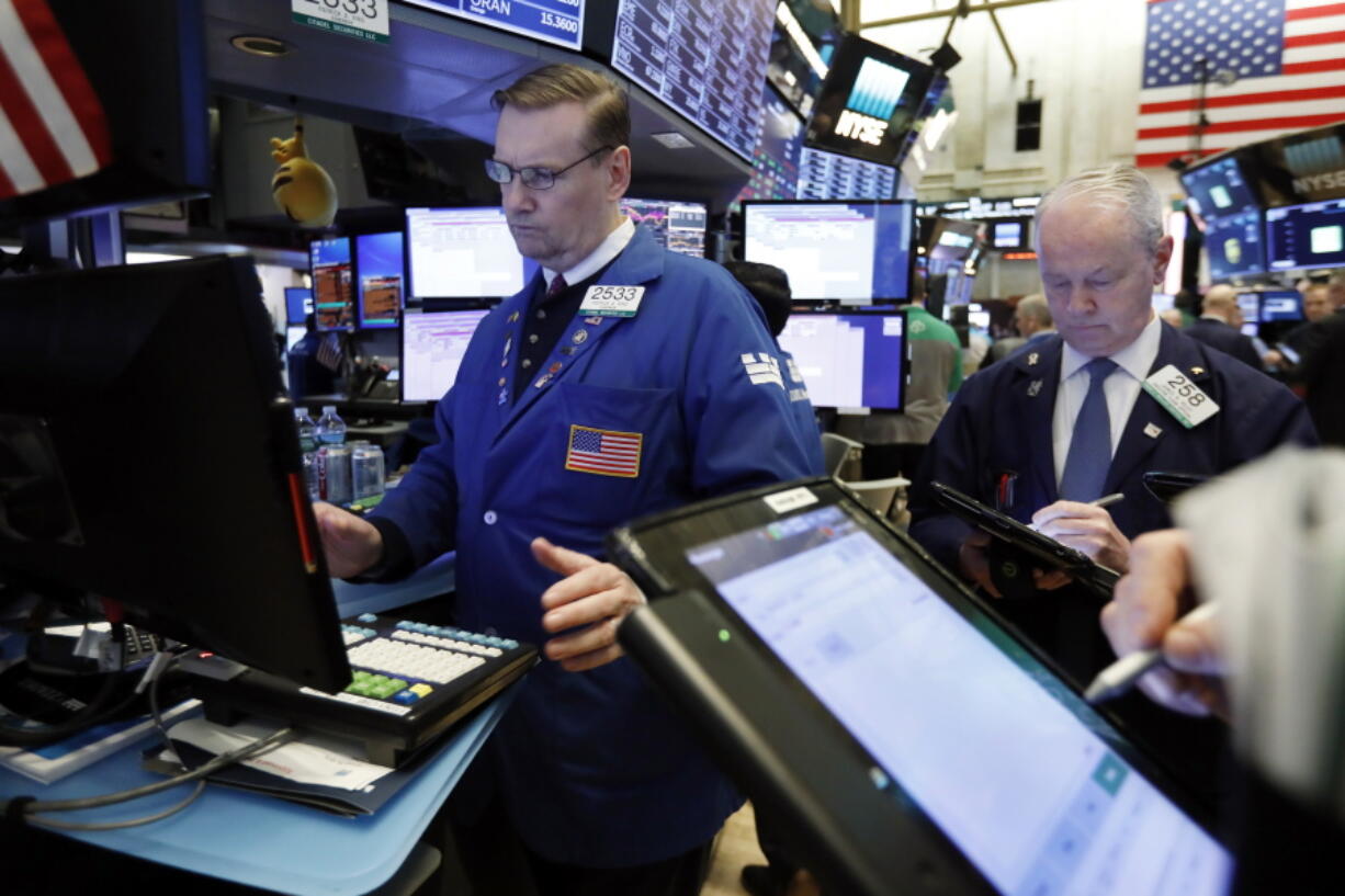 FILE- In this Tuesday, Jan. 29, 2019, file photo specialist Patrick King, left, works on the floor of the New York Stock Exchange. The U.S. stock market opens at 9:30 a.m. EST on Wednesday, Feb. 6.