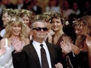 German fashion designer Karl Lagerfeld acknowledges the applause of his models at the end of the show he designed for the French fashion house Chanel, for the 1993-94 Fall-Winter haute couture collection in Paris, July 20, 1993. At left background is German top model Claudia Schiffer. Chanel’s iconic couturier, Karl Lagerfeld, whose accomplished designs as well as trademark white ponytail, high starched collars and dark enigmatic glasses dominated high fashion for the last 50 years, has died. He was around 85 years old.