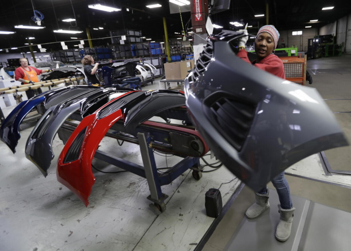 FILE-This Wednesday, Nov. 28, 2018 file photo shows Mari Keels transferring a front end of a General Motors Chevrolet Cruze during assembly at Jamestown Industries, in Youngstown, Ohio. Jamestown Industries, which supplies front and rear bumper covers for the Cruze, hopes its efforts to secure new business will allow its Youngstown plant to keep going. But the plant is down from three shifts to one and GM is still its biggest customer.