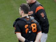 San Francisco Giants manager Bruce Bochy, top, talks with catcher Buster Posey during a baseball spring training practice, Wednesday, Feb. 13, 2019, in Scottsdale, Ariz.