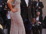 FILE - In this file photo taken on Aug. 31, 2018, director Spike Lee, left, wearing a Gucci outfit, and Tonya Lee Lewis pose for photographers upon arrival at the premiere of the film ‘A Star Is Born’ at the 75th edition of the Venice Film Festival in Venice, Italy. Director Spike Lee said Friday, Feb. 8, 2019, he will no longer wear Gucci or Prada until the brands hire some black designers, ‘‘To Be In Da Room When It Happen” following a pair of blackface fashion fails.