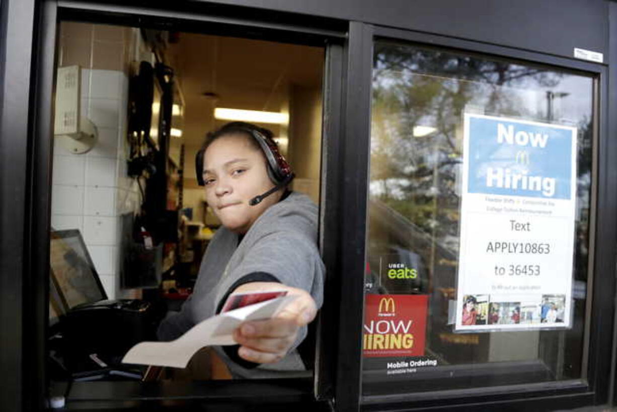 In this Jan. 3, 2019, file photo a cashier returns a credit card and a receipt at a McDonald’s window, where signage for job openings are displayed in Atlantic Highlands, N.J. On Tuesday, Feb. 12, the Labor Department reports on job openings and labor turnover for December.