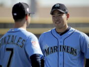 Seattle Mariners pitcher Yusei Kikuchi, from Japan, talks to pitcher Marco Gonzales during spring training baseball practice Tuesday, Feb. 12, 2019, in Peoria, Ariz.