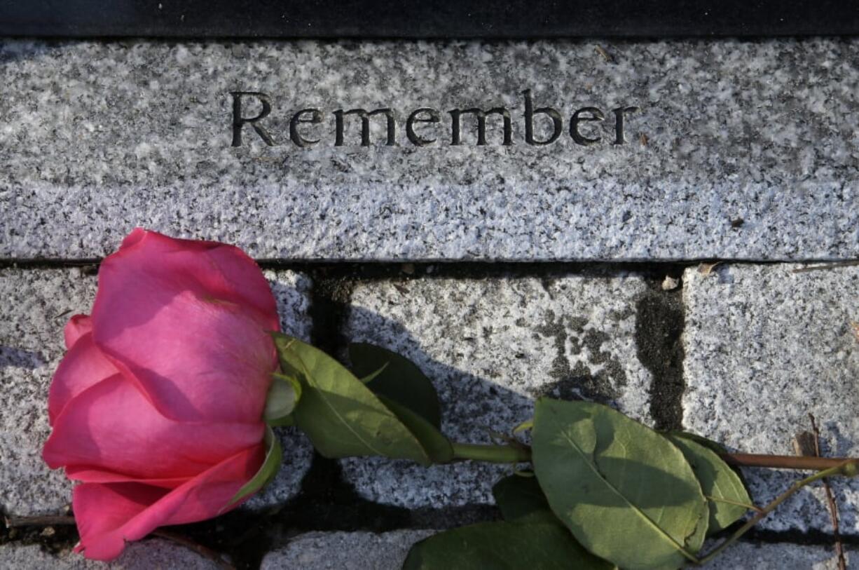 FILE - In this Feb. 20, 2018 file photo, a flower rests near a memorial to a victim of the Station nightclub fire following in West Warwick, R.I. The Feb. 20, 2003, fire that killed 100 and injured more than 200 others, started when pyrotechnics for the rock band Great White set fire to flammable foam installed as soundproofing. The site of the fire is now a memorial park.