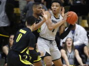 Colorado guard Tyler Bey, right, looks to pass the ball as Oregon forward Francis Okoro, back left, and guard Will Richardson defend in the first half of an NCAA basketball game Saturday, Feb. 2, 2019, in Boulder, Colo.