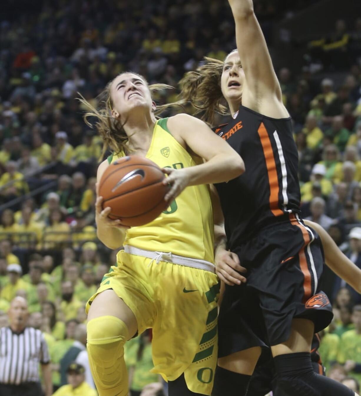 Oregon’s Sabrina Ionescu, left, goes up to shoot against Oregon State’s Mikayla Pivec during the second quarter of an NCAA college basketball game Friday, Feb. 15, 2019, in Eugene, Ore.