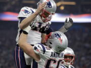 New England Patriots’ David Andrews (60) picks up Tom Brady (12) after the Patriots scored a touchdown during the second half of the NFL Super Bowl 53 football game against the Los Angeles Rams Sunday, Feb. 3, 2019, in Atlanta.