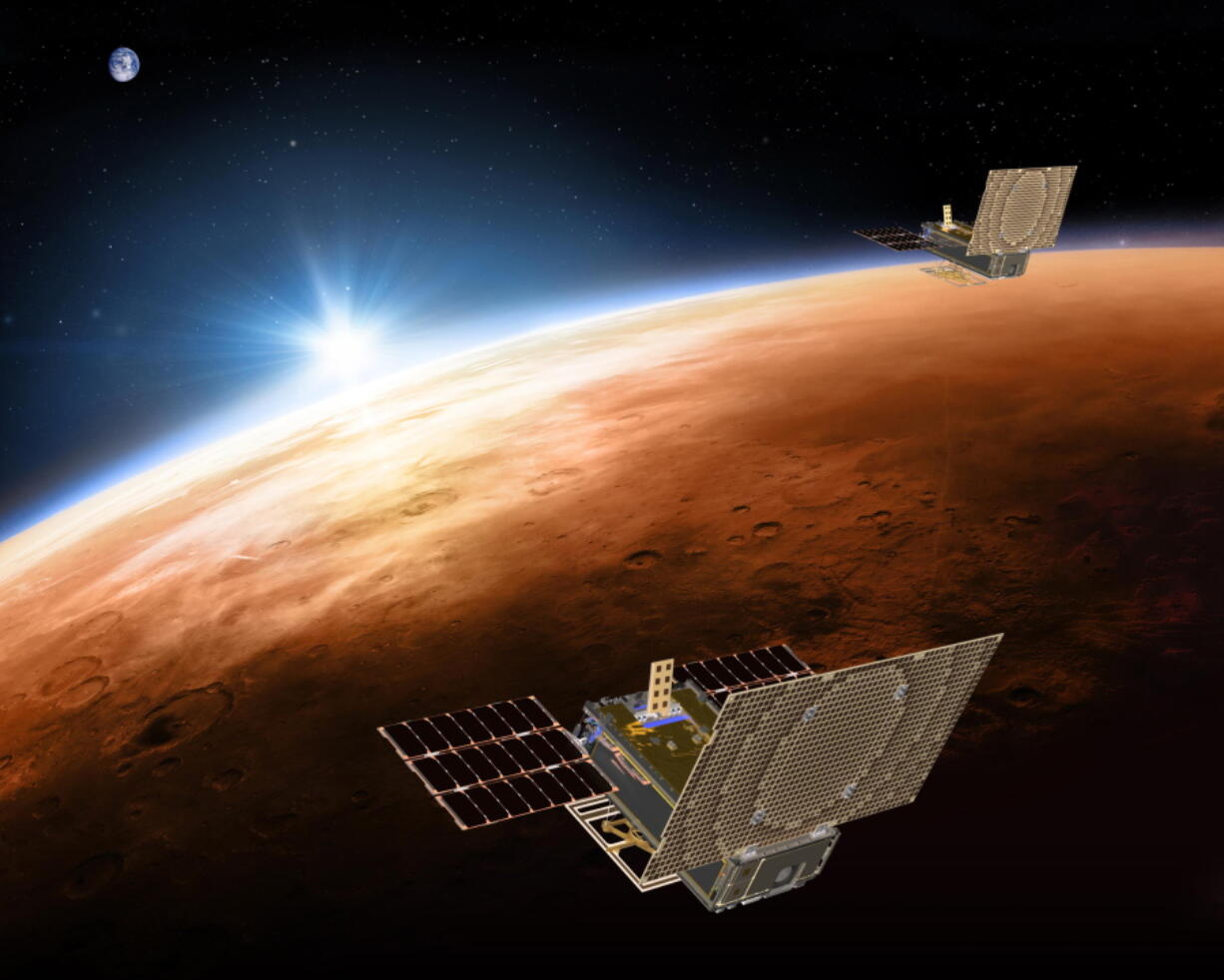 The twin Mars Cube One spacecraft fly over Mars with Earth and the sun in the distance.