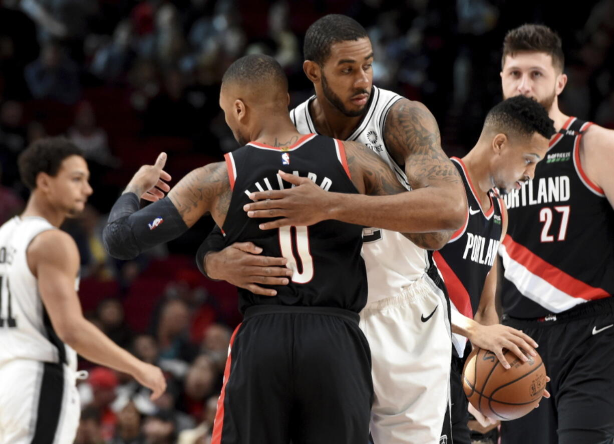 Portland Trail Blazers guard Damian Lillard, front, greets a former teammate, San Antonio Spurs center LaMarcus Aldridge, before an NBA basketball game in Portland, Ore., Thursday, Feb. 7, 2019.