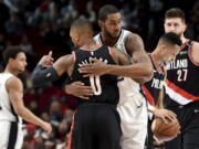 Portland Trail Blazers guard Damian Lillard, front, greets a former teammate, San Antonio Spurs center LaMarcus Aldridge, before an NBA basketball game in Portland, Ore., Thursday, Feb. 7, 2019.