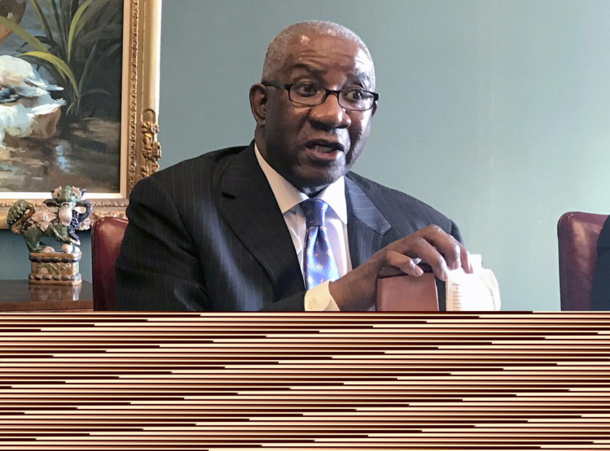 FILE - In this Aug. 17, 2018, file photo, Pulaski County Circuit Judge Wendell Griffen holds a copy of the U.S. Constitution at a news conference in Little Rock, Ark. The Supreme Court is leaving in place a decision dismissing a lawsuit filed by a judge in Arkansas who was barred from overseeing execution-related cases after he participated in an anti-death penalty demonstration.