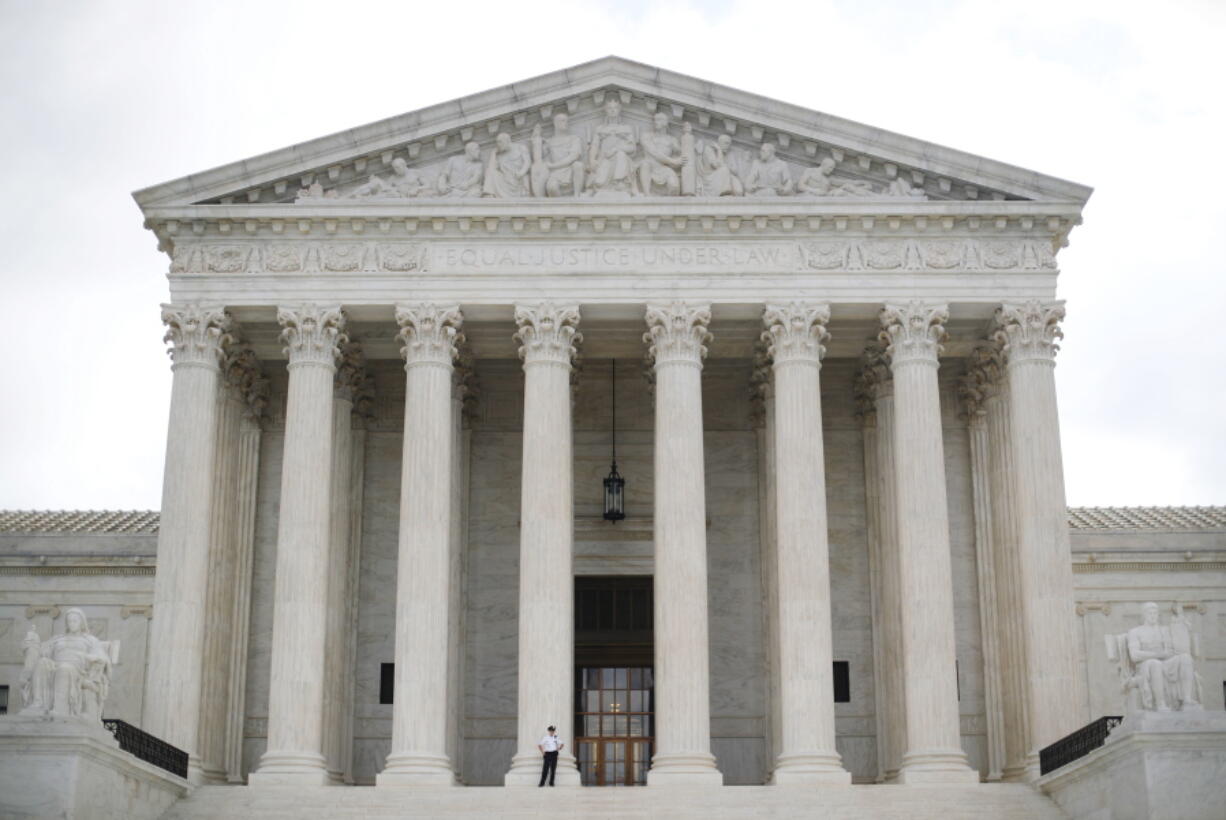 In this Oct. 9, 2018 photo, police office guards the main entrance to the Supreme Court in Washington. The Supreme Court has agreed to consider a case about the reach of a federal clean water law. The justices agreed Tuesday to hear a case involving the Clean Water Act.