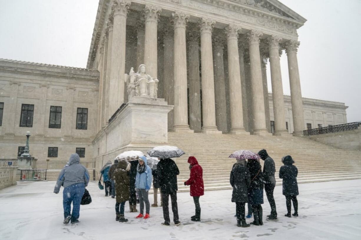 Visitors wait to enter the Supreme Court as a winter snow storm hits the nation’s capital making roads perilous and closing most Federal offices and all major public school districts, on Capitol Hill in Washington, Wednesday, Feb. 20, 2019. The Supreme Court is ruling unanimously that the Constitution’s ban on excessive fines applies to the states. The outcome Wednesday could help an Indiana man recover the $40,000 Land Rover police seized when they arrested him for selling about $400 worth of heroin. (AP Photo/J.