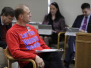 Anti-tax initiative promoter Tim Eyman, center, waits before speaking during a Feb. 13 public hearing of the Senate State Government, Tribal Relations, and Elections Committee at the Capitol in Olympia. Eyman testified Tuesday in favor of his “Bring Back Our $30 Car Tabs” initiative.