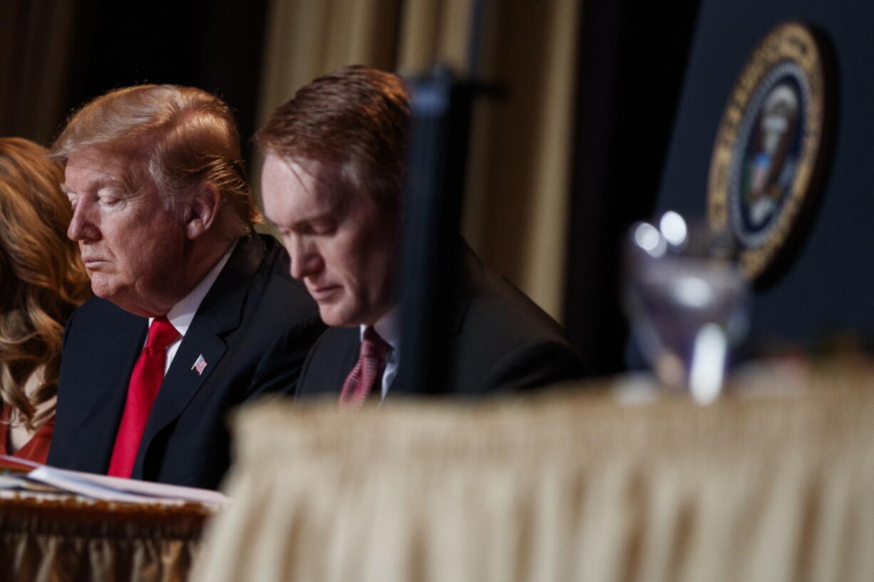 President Donald Trump and Rep. James Lankford, R-Okla., pray during the National Prayer Breakfast, Thursday, Feb. 7, 2019, in Washington.