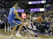 Washington guard David Crisp (1) drives around UCLA forward Alex Olesinski (0) during the second half of an NCAA college basketball game, Saturday, Feb. 2, 2019, in Seattle. Washington won 69-55. (AP Photo/Ted S.