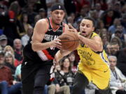 Portland Trail Blazers guard Seth Curry, left, drives to the basket on Golden State Warriors guard Stephen Curry during the second half of an NBA basketball game in Portland, Ore., Wednesday, Feb. 13, 2019. The Blazers won 129-107.