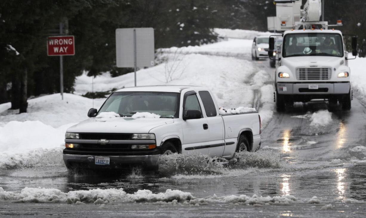 A truck drives through standing water on a highway offramp, Tuesday, Feb. 12, 2019, in Olympia, Wash. As heavy snow turned into rain Tuesday in the Pacific Northwest, crews worked to clear drains and roadways as concerns about flooding and drainage increased. February has been the snowiest month for the area in more than 50 years, and the National Weather Service issued a flood watch for northwest Oregon and parts of Washington through Wednesday morning. (AP Photo/Ted S.