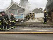 Firefighters air out the basement of a home that caught fire Tuesday afternoon in Fourth Plain Village.