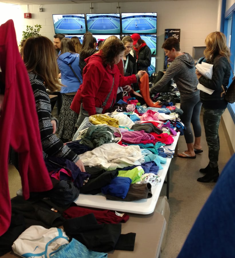 Players and parents search over tennis clothing during the Vancouver Tennis Center Foundation gear swap on Sunday, March 3, 2019. The 2020 gear swap is Sunday, March 8.