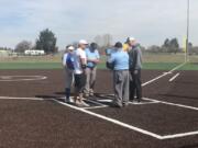 Coaches from La Center and Hudson's Bay meet with umpires before the second game of Saturday's Trapper Softball Classic.