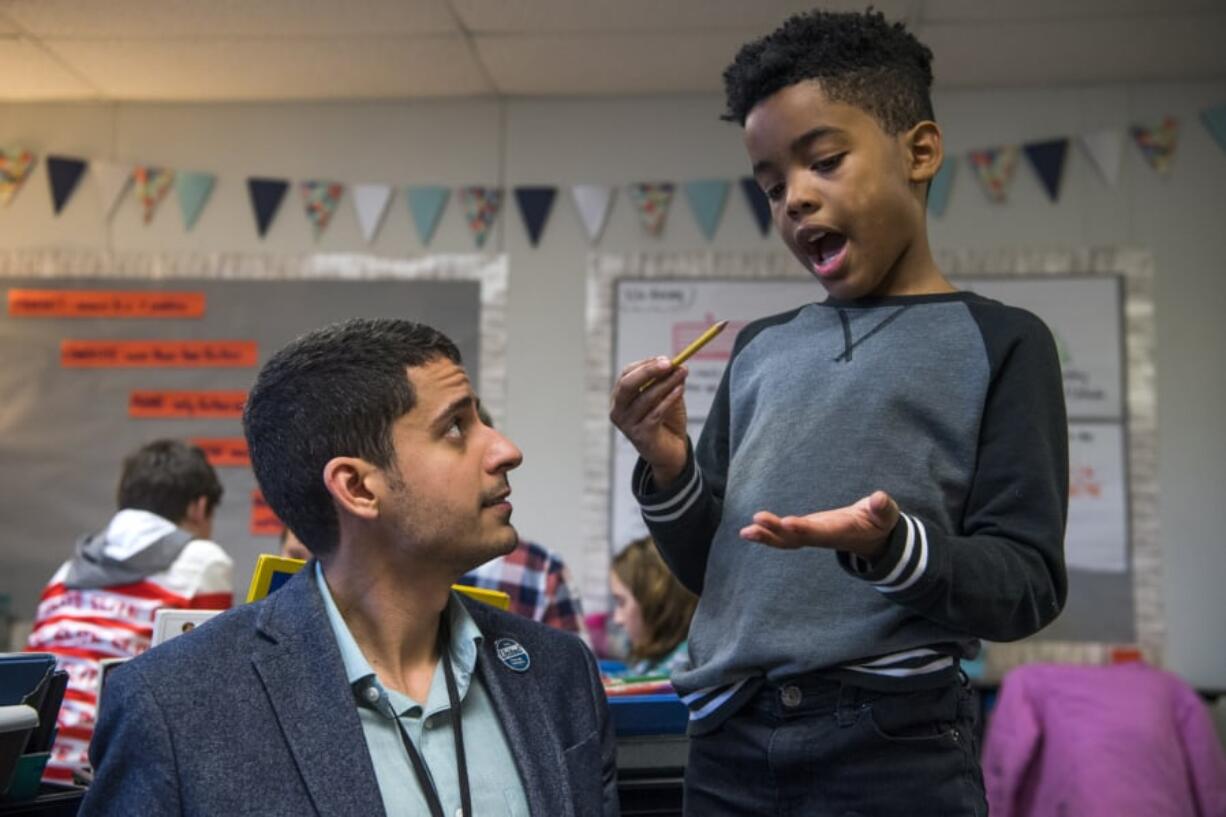 Teacher Adam Aguilera helps fourth-grader Kaler Mathews with a math exercise in November at Pioneer Elementary School in Vancouver.