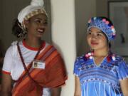 Nesteha Hassen, 17, left, of Ethiopia and Ywahay Moo, 16, of Thailand are dressed in native garb waiting to walk the runway at a fashion show in Leucadia featuring young women who are recent refugees to the United States.