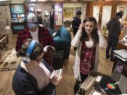 Washington State University Vancouver history students Ruby Burke, left, Brian Sanchez and Katie O’Boyle sample the sound technologies of yesteryear while studying “Music, Movement and Sound,” an interactive exhibit that opened in January at the Clark County Historical Museum.