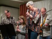 Six-year-old Megan Wilder helps her grandmother, Eilene Laing, sing “You Are My Sunshine” during the biweekly gathering of the Columbia River Old Time Strings at the Minnehaha Grange. Accompanying them are Jerry Jacobs on guitar and Ron Coon on bass. Randy L.