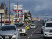 Motorists drive past businesses along a stretch of Highway 99 in Hazel Dell, shown using a telephoto lens that compresses the view. The Highway 99 corridor is considered to be an economic development priority by the Clark County Council, which is part of why the area was selected as one of the county’s seven Opportunity Zones, a new federal designation aimed at encouraging local investment.