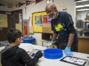 Greg Davis, day custodian, helps students organize their lunch plates for the cafeteria composting system at Martin Luther King Elementary School in Vancouver. Davis has worked for the school district since 1986 and at Martin Luther King Elementary School for 25 years. He has plans to retire shortly after the school makes a big move to a new building by September 2020.