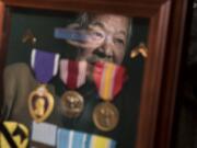 Ian Fujisaki is reflected in a shadowbox filled with medals he earned during the Korean War, while at his Vancouver home. Fujisaki was drafted into the U.S. Army in 1951 and earned a Purple Heart when a piece of shrapnel cut his hand.