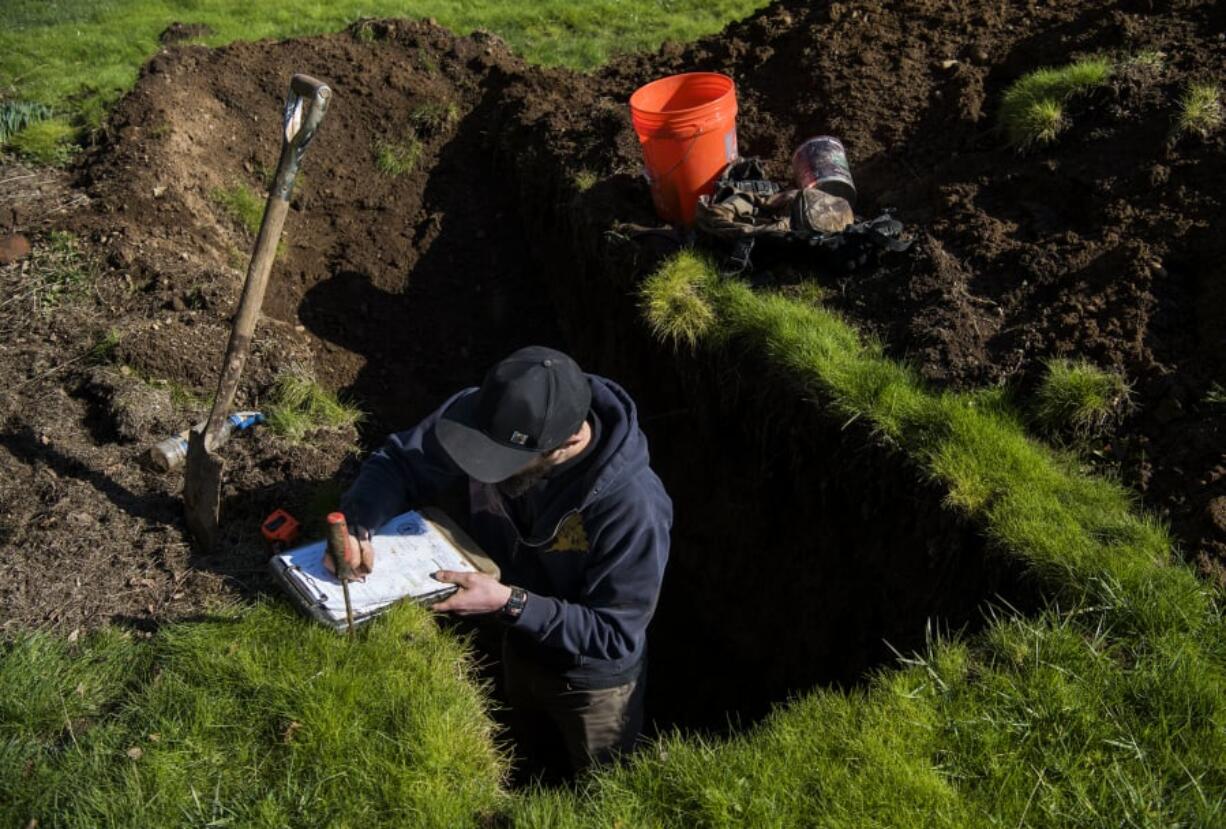 Antonio Delgado, an environmental health specialist with Clark County, tests the soil where a septic system was proposed in 2019 in Ridgefield.