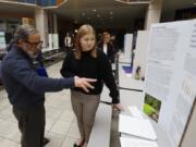 Columbia River High School junior Sydney Boyle, right, discusses her project with judge Mike Ellison at the annual SW Washington Science and Engineering Fair at Skyview high school. Boyle looked at how plants can reduce nitrogen in runoff water.