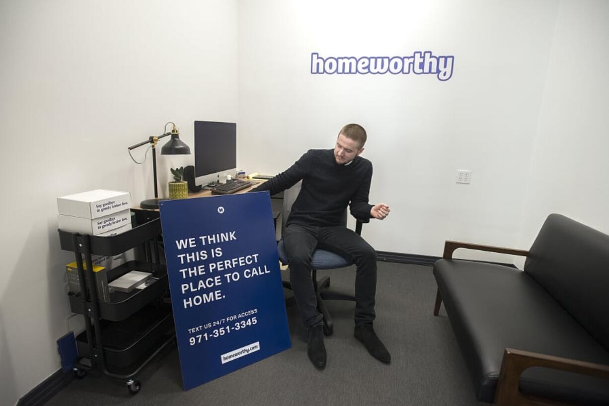 Corey Walters, founder and CEO of Homeworthy, looks over one of his company’s “for sale” signs in his downtown Vancouver office. The signs are intended to be hung from full-size posts like a traditional For Sale sign, but with a more distinctive look.