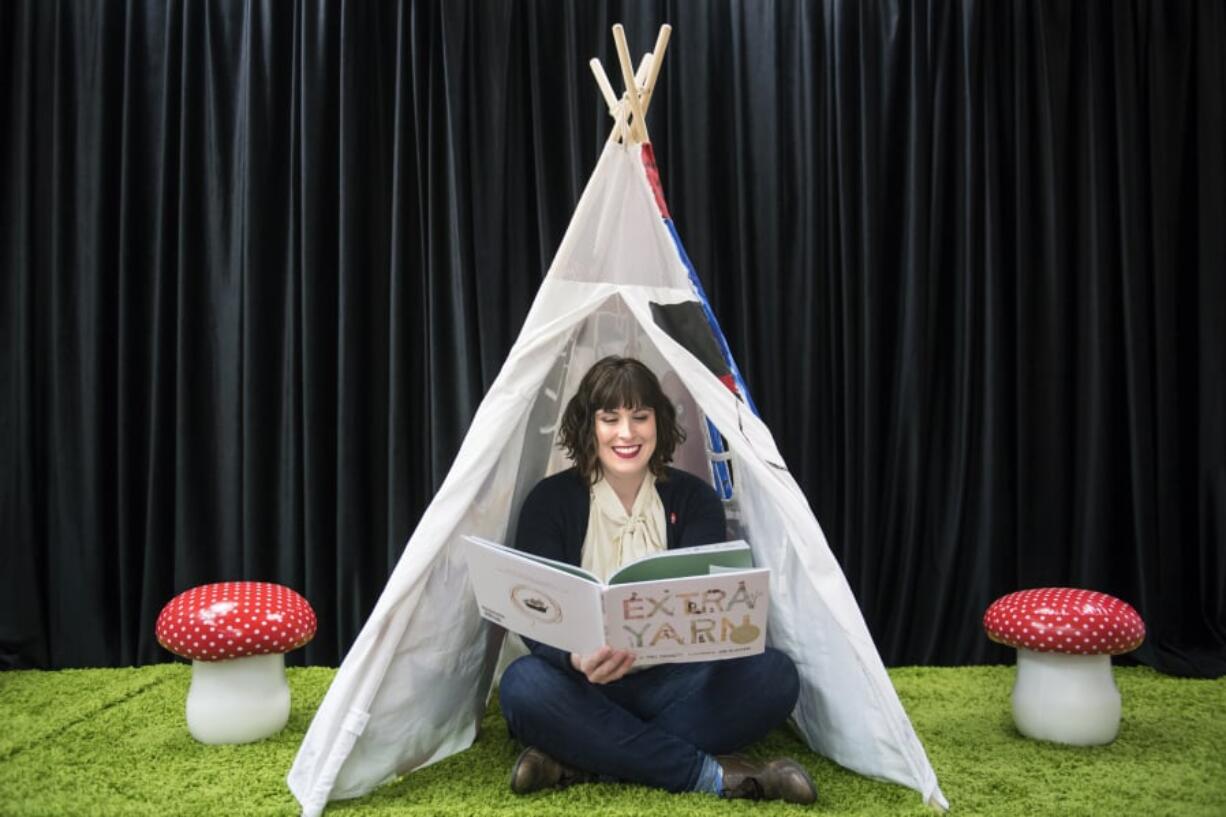 Kari Ferguson, owner of Dickens Children’s Books and Publishing Lab, sits in the reading area of her new bookstore in the Hough neighborhood. The stage area will also allow for puppet shows, live music performances and story time reading sessions.