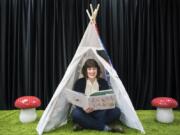 Kari Ferguson, owner of Dickens Children’s Books and Publishing Lab, sits in the reading area of her new bookstore in the Hough neighborhood. The stage area will also allow for puppet shows, live music performances and story time reading sessions.