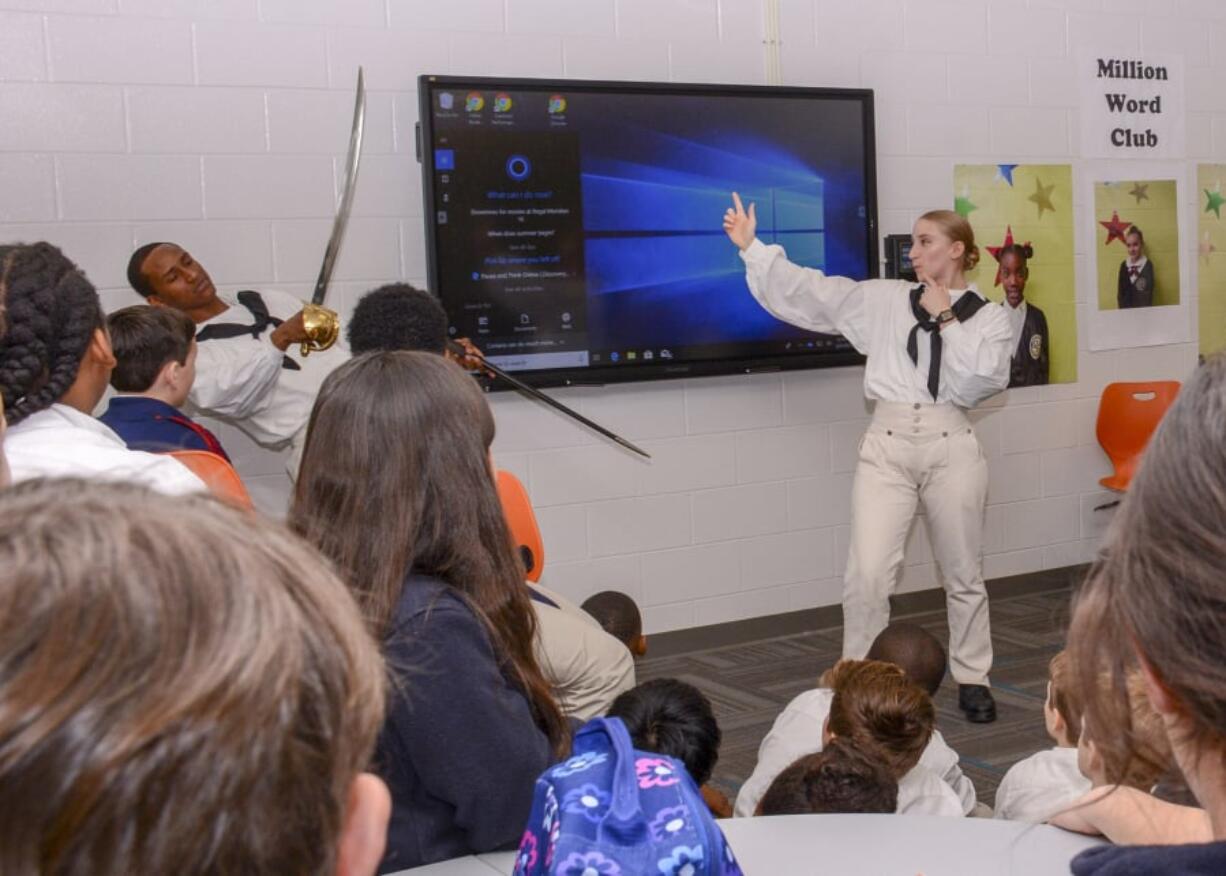 Seaman Ana Tomic of Vancouver and Personnel Specialist Seaman Jordan A. Young of Red Oak, Texas, reenact a battle for watching students. U.S. Navy photo by Airman Olivia K.