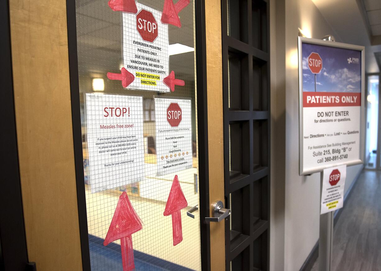 Signs warns visitors to stay away if they have measles at Evergreen Pediatric Clinic.