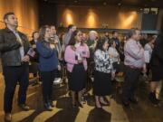 New American citizens recite the Pledge of Allegiance during a naturalization ceremony Thursday morning at Vancouver Community Library. They also recited the oath of allegiance, in which they gave up loyalty to their countries of origin and became U.S. citizens.