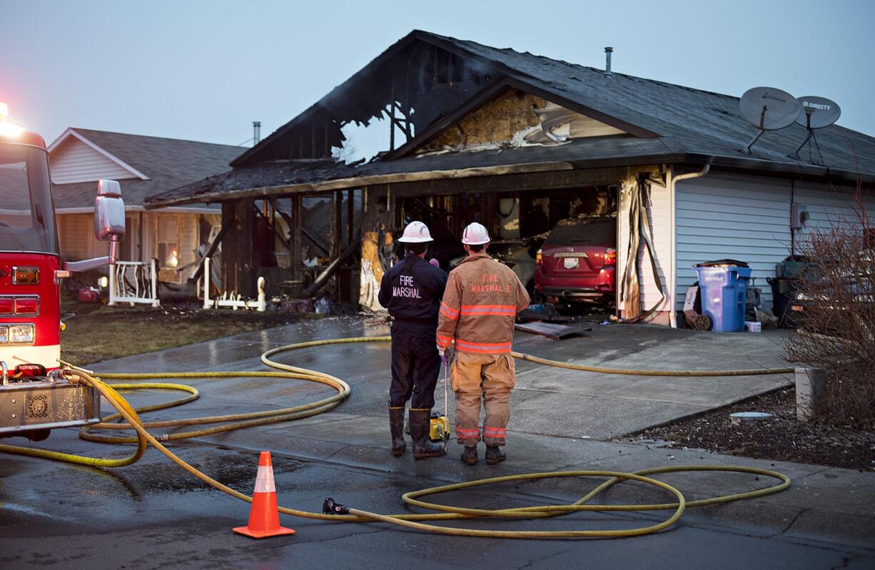 Officials investigate after a fast-moving fire destroyed a home in the Five Corners area of Vancouver on Wednesday morning, March 6, 2019. A relative said a family of six lost their home and their belongings in the blaze.