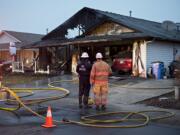 Officials investigate after a fast-moving fire destroyed a home in the Five Corners area of Vancouver on Wednesday morning, March 6, 2019. A relative said a family of six lost their home and their belongings in the blaze.